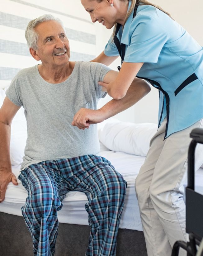 Caregiver providing specialized ALS support including mobility assistance and communication device facilitation at home in Los Angeles.